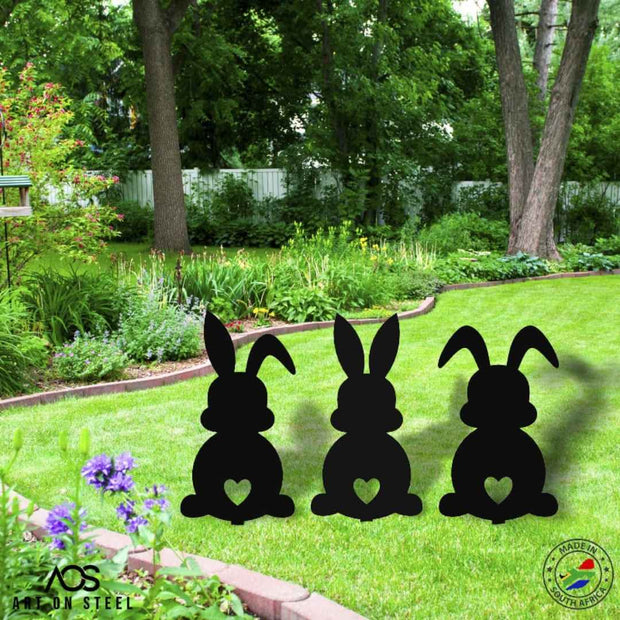Set of 3 steel bunny silhouettes with heart cut-out design — black metal garden décor by Art on Steel, cute Easter and outdoor lawn ornaments, durable handmade decorations made in South Africa.
