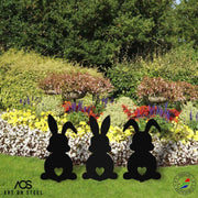 Set of 3 bunny garden ornaments with heart cut-out design — black steel silhouettes by Art on Steel, decorative metal rabbit figures for flower beds, Easter lawn décor, durable handmade outdoor decorations made in South Africa.
