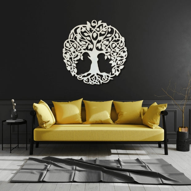 Yellow sofa with decorative pillows against a black wall with a tree of life design.