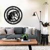 A circular black metal sign featuring a stylized horse head with a flowing mane in the center. The text "CUSTOM NAME" and "HORSE STABLES" is written around the border. The sign is mounted on a light-colored wall above a gray couch in a modern living room, with a live-edge coffee table, a black lamp, and a white vase. The "Art on Steel" logo is visible in the top right corner.