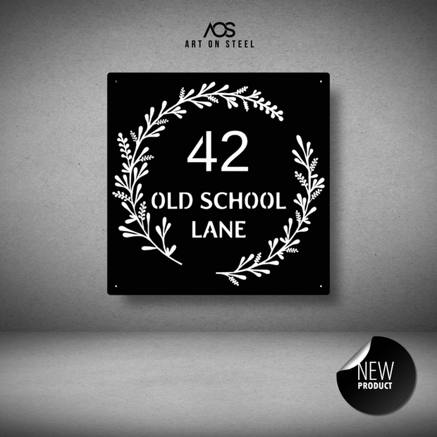 Decorative house number sign with foliage design on a gray background, featuring '42 Old School Lane' text.