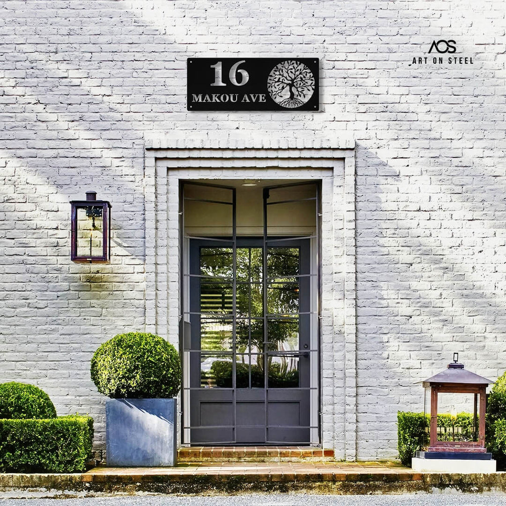 Gray door with decorative house number plate on a white brick wall, from Art on Steel.