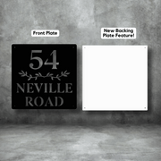 Two house number signs, one black with '54 Neville Road' text and one white with 'New Backing Plate Feature!' text, on a gray background.