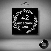 Wreath-inspired house number with '42 Old School Lane' text on a gray background, featuring the brand 'Art On Steel'. features a white backing plate 